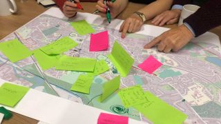 people pointing at a map with post its
