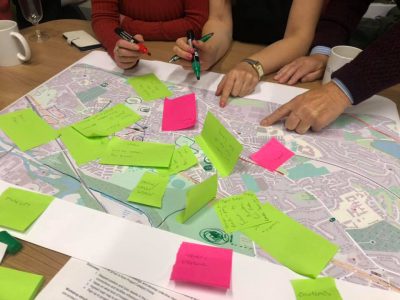 people pointing at a map with post its